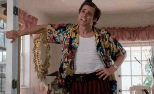 A Man In A Colorful Shirt Is Standing In Front Of A Door GIF
