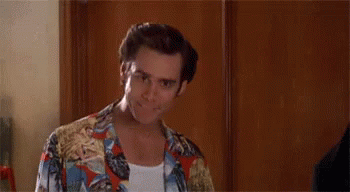 A Man In A Colorful Shirt Is Standing In Front Of A Wooden Door And Says `` Alright Then ! '' GIF