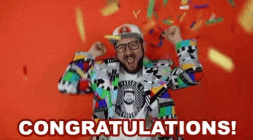A Man In A Colorful Suit Is Celebrating With Confetti Falling Around Him And The Words Congratulations ! GIF