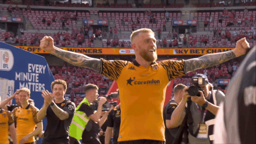 A Man In A Corwudun Jersey Stands In Front Of A Sign That Says " Every Minute Matters " GIF