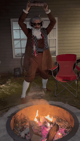 A Man In A Costume Is Standing In Front Of A Fire Pit GIF