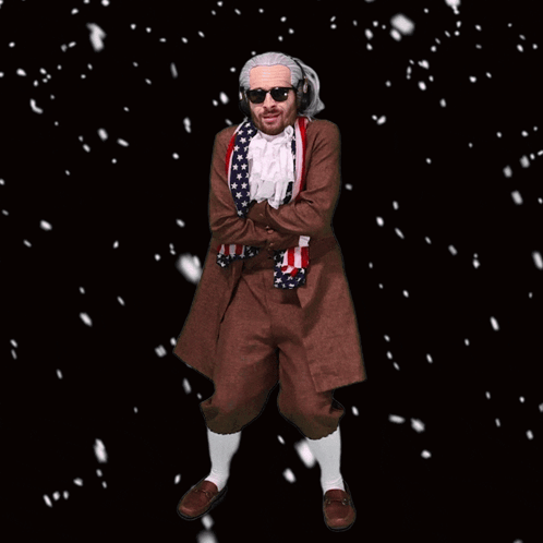 A Man In A Costume With An American Flag Around His Neck Is Standing In The Snow GIF