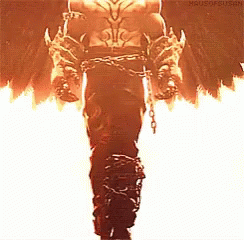A Man In A Costume With Chains Around His Waist Is Standing In Front Of Flames . GIF