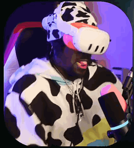 A Man In A Cow Costume Is Wearing A Virtual Reality Headset In Front Of A Microphone GIF