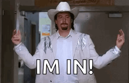 A Man In A Cowboy Hat And Suit Is Standing In Front Of A Door . GIF