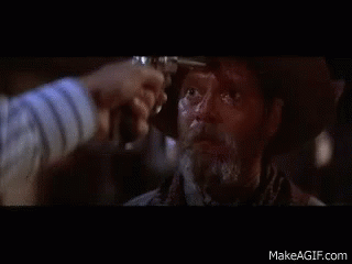 A Man In A Cowboy Hat Is Being Shot By Another Man With A Gun GIF
