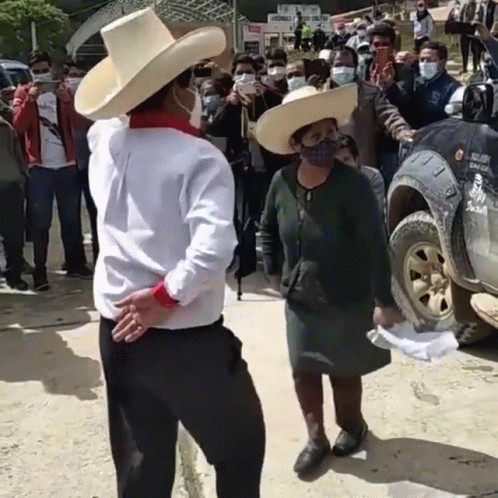A Man In A Cowboy Hat Is Dancing With A Woman In A Mask GIF
