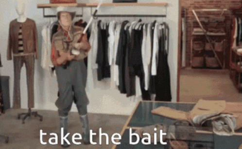 A Man In A Cowboy Hat Is Holding A Fishing Rod And The Words Take The Bait Are Above Him GIF