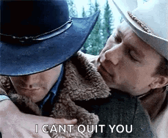 A Man In A Cowboy Hat Is Hugging Another Man In A Fur Coat . GIF