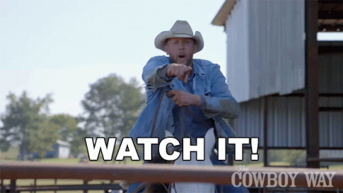 A Man In A Cowboy Hat Is Pointing At Something With The Words " Watch It " Above Him GIF