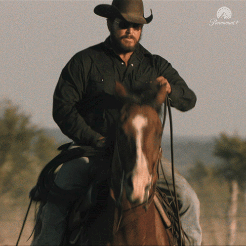 a man in a cowboy hat is riding a horse with a paramount logo on the bottom