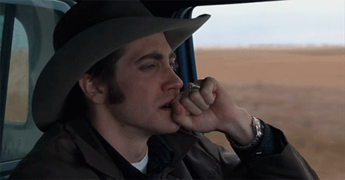 A Man In A Cowboy Hat Is Smoking A Cigarette In A Car GIF