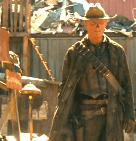 A Man In A Cowboy Hat Is Standing In Front Of A Clothing Store GIF