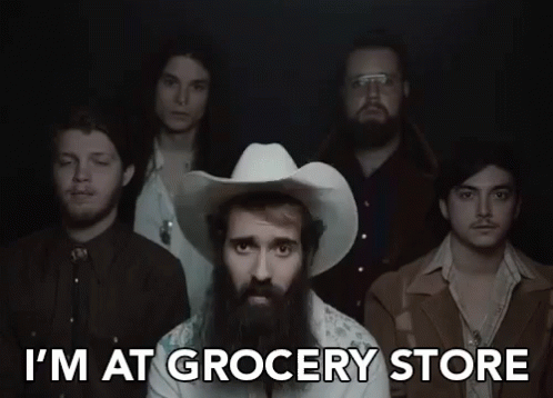 A Man In A Cowboy Hat Is Standing In Front Of A Group Of Men And Says I 'M At Grocery Store GIF