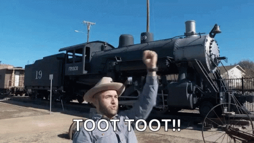 A Man In A Cowboy Hat Is Standing In Front Of A Train That Says Fresco On It GIF