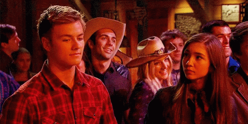 A Man In A Cowboy Hat Is Standing Next To A Woman GIF