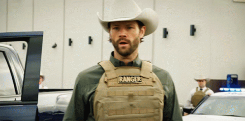 a man in a cowboy hat is wearing a vest that says ranger