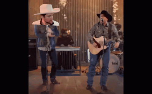 A Man In A Cowboy Hat Sings Into A Microphone GIF