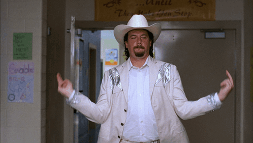 A Man In A Cowboy Hat Stands In Front Of A Sign That Reads " Until They Make You Stop " GIF