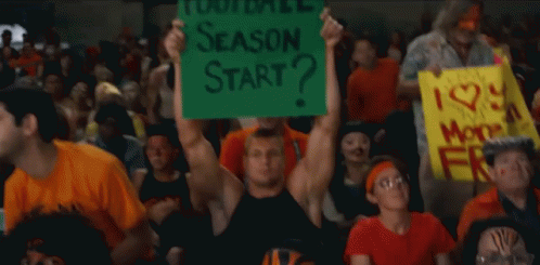 A Man In A Crowd Holds Up A Sign That Says Season Start GIF
