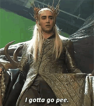 A Man In A Crown Is Sitting On A Chair And Saying `` I Gotta Go Pee '' . GIF