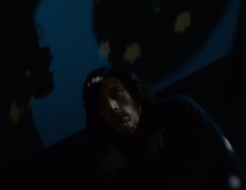 A Man In A Dark Room With A Star Projected On The Wall Behind Him GIF