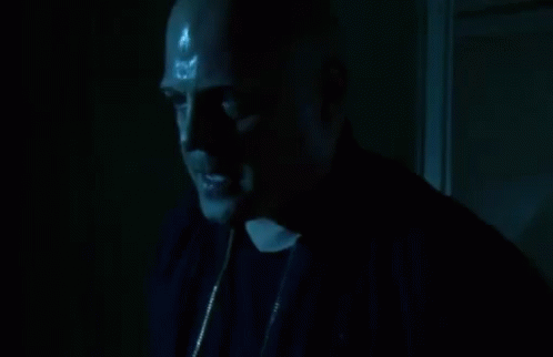 A Man In A Dark Room With Sweat Coming Out Of His Forehead GIF