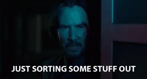 a man in a dark room with the words `` just sorting some stuff out '' written on the bottom .