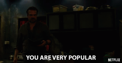 A Man In A Dark Room With The Words " You Are Very Popular " Above Him GIF