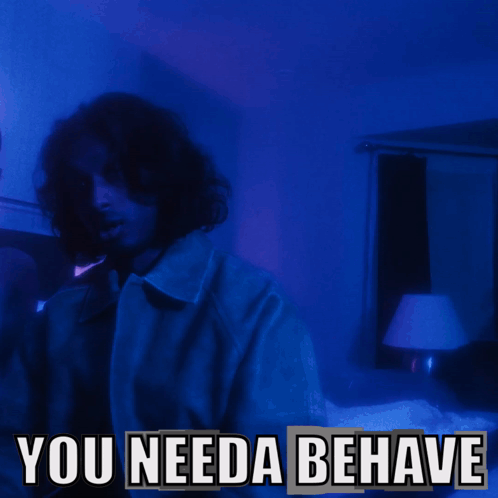 A Man In A Dark Room With The Words " You Needa Behave " Below Him GIF