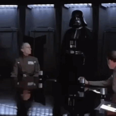 A Man In A Darth Vader Costume Is Standing In Front Of A Group Of Men Sitting At A Table GIF