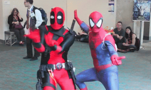 A Man In A Deadpool Costume And A Man In A Spiderman Costume Are Dancing Together . GIF