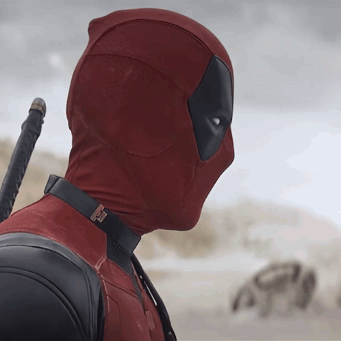 a man in a deadpool costume holds a sword in his hand