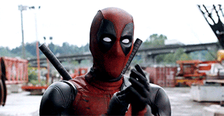A Man In A Deadpool Costume Is Holding A Gun In His Hands . GIF
