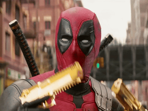 A Man In A Deadpool Costume Is Holding A Gun GIF