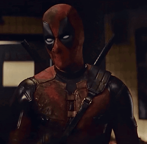 A Man In A Deadpool Costume Is Holding A Sword GIF