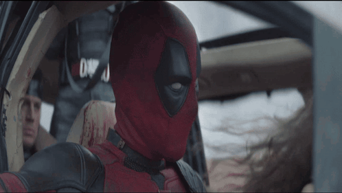 A Man In A Deadpool Costume Is In A Car GIF