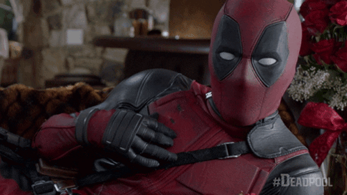 A Man In A Deadpool Costume Is Laying Down On A Couch GIF
