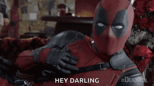 A Man In A Deadpool Costume Is Laying On A Bed And Saying Hey Darling GIF