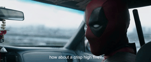 A Man In A Deadpool Costume Is Sitting In The Driver 'S Seat Of A Car GIF