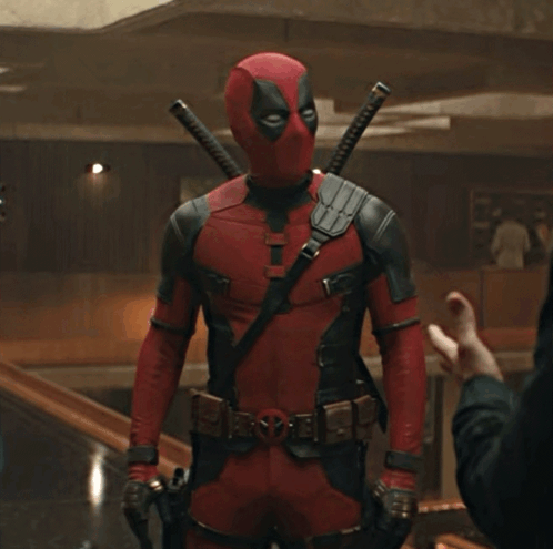A Man In A Deadpool Costume Is Standing In A Room GIF
