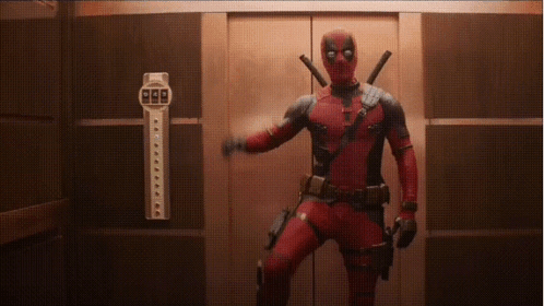 A Man In A Deadpool Costume Is Standing In An Elevator Holding A Gun . GIF
