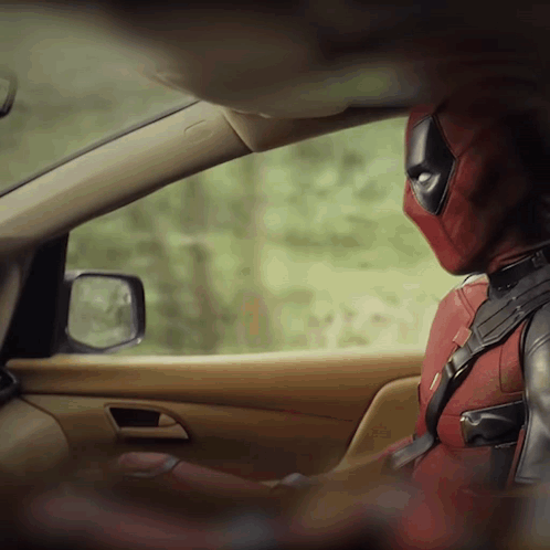 A Man In A Deadpool Costume Sits In A Car GIF