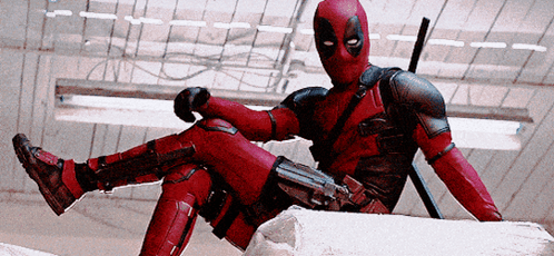 A Man In A Deadpool Costume Sits On A Rock GIF