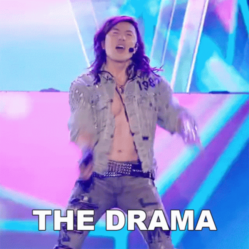 A Man In A Denim Jacket Is Dancing On A Stage With The Word The Drama Below Him GIF