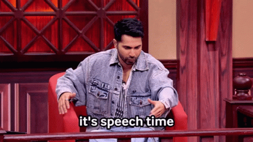 A Man In A Denim Jacket Is Sitting In A Chair With The Words It 'S Speech Time Below Him GIF