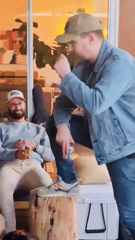 A Man In A Denim Jacket Is Standing Next To A Man In A Baseball Cap GIF
