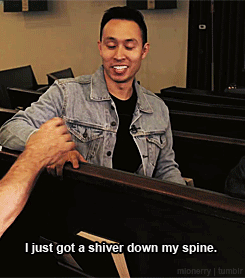 A Man In A Denim Jacket Is Talking To Another Man In A Black Shirt GIF