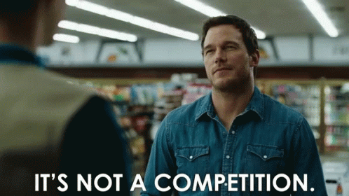 A Man In A Denim Shirt Is Saying It 'S Not A Competition GIF