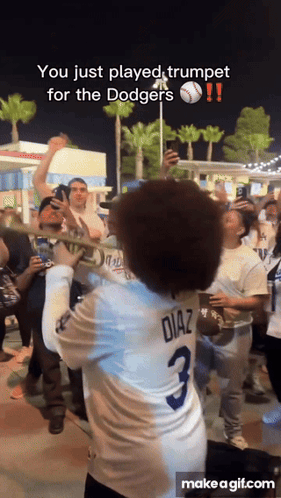 A Man In A Diaz Jersey Plays Trumpet In Front Of A Crowd GIF